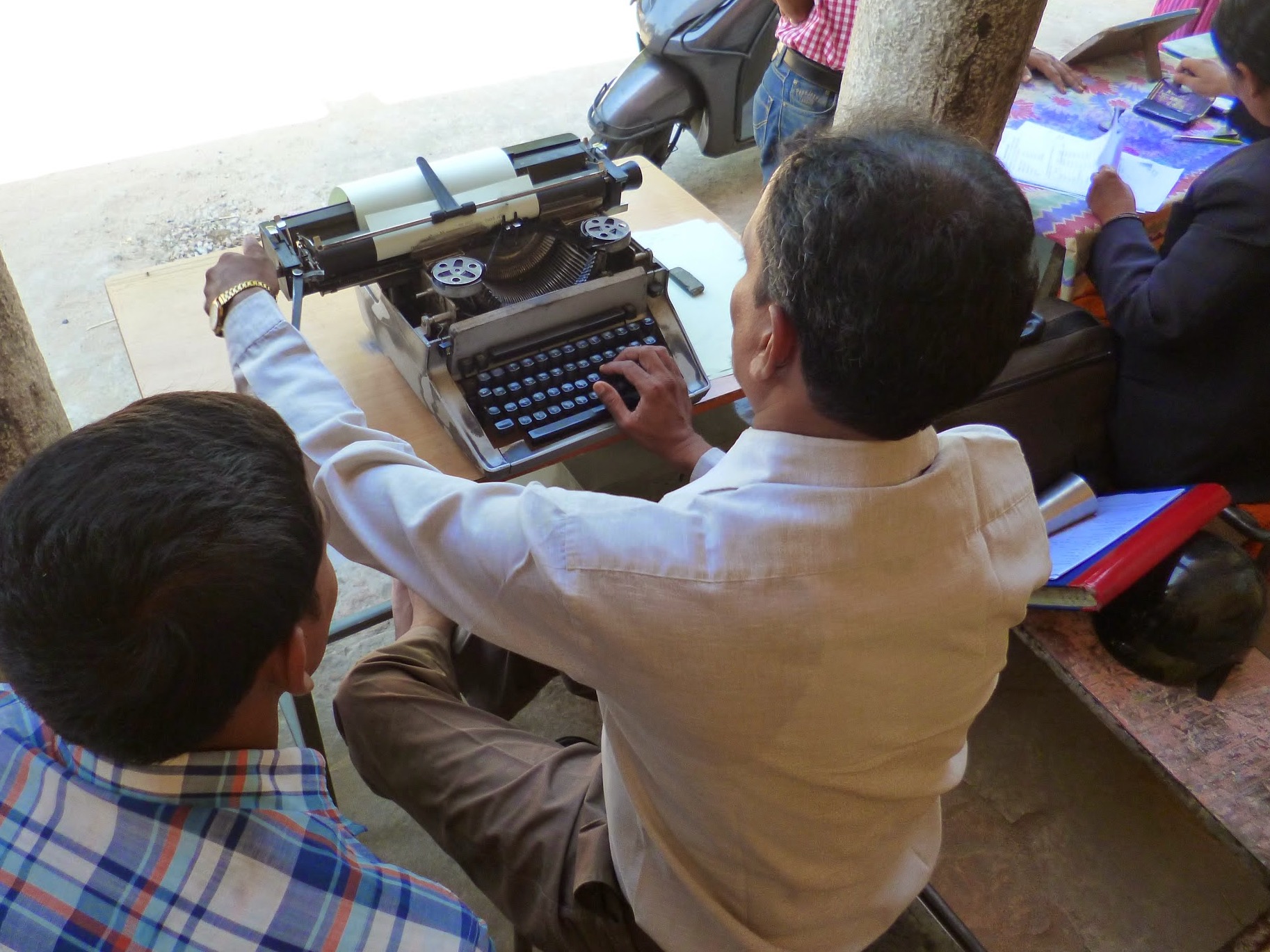 Man working on typewriter, image by Media Helping Media